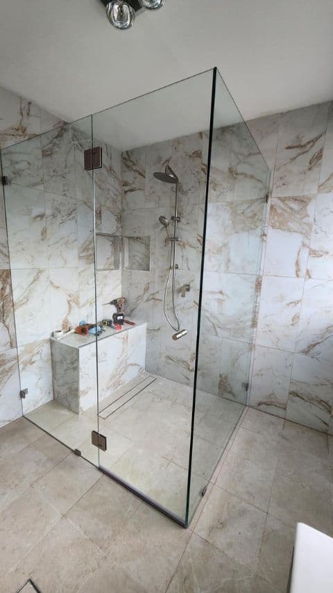 Completed frameless shower screen with brushed nickel hardware