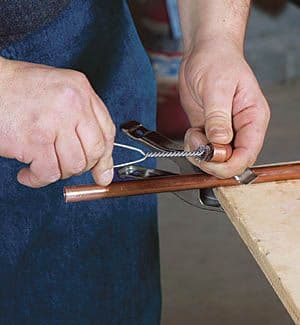 Plumber soldering a copper pipe joint in a service riser