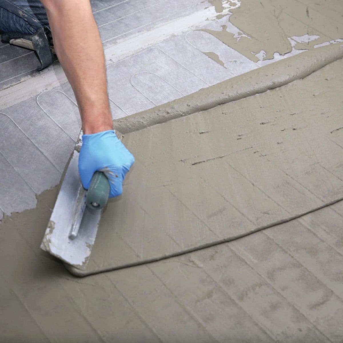 Cement screeding being poured on a concrete subfloor