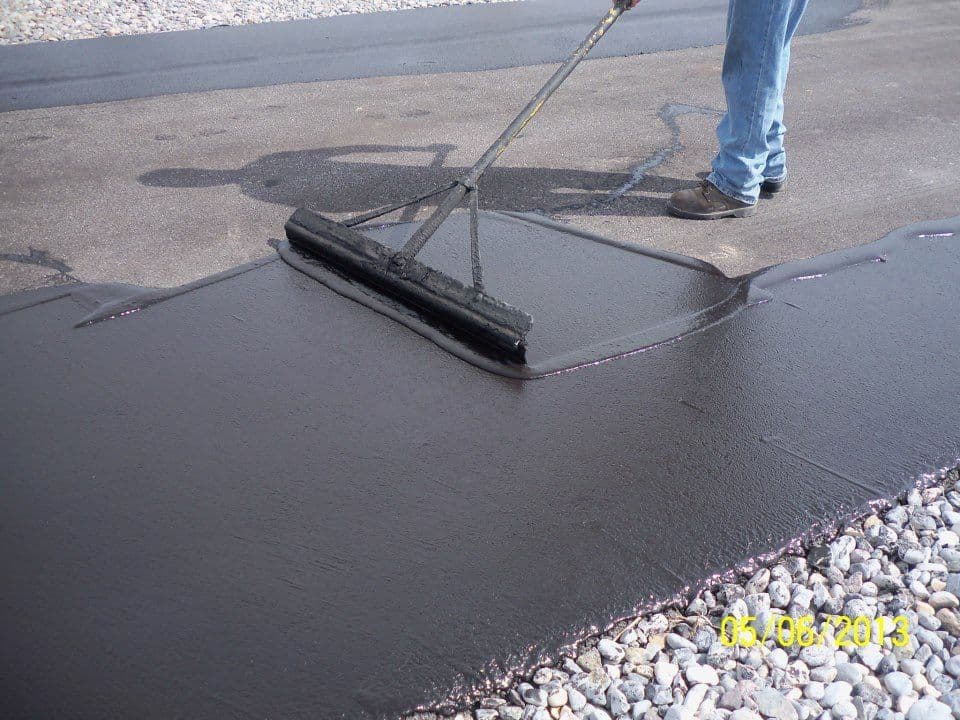Applying cementitious waterproofing slurry on a bathroom floor