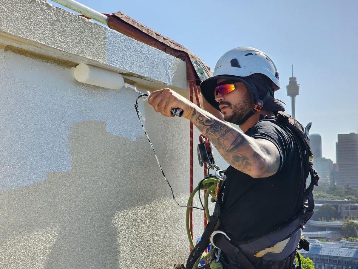 Spraying clear waterproof sealer on a condo external wall