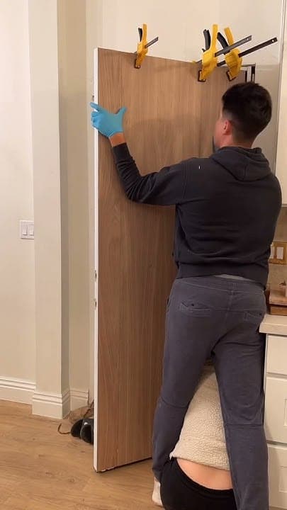 Carpenter planing the bottom of a wooden door that drags on the floor