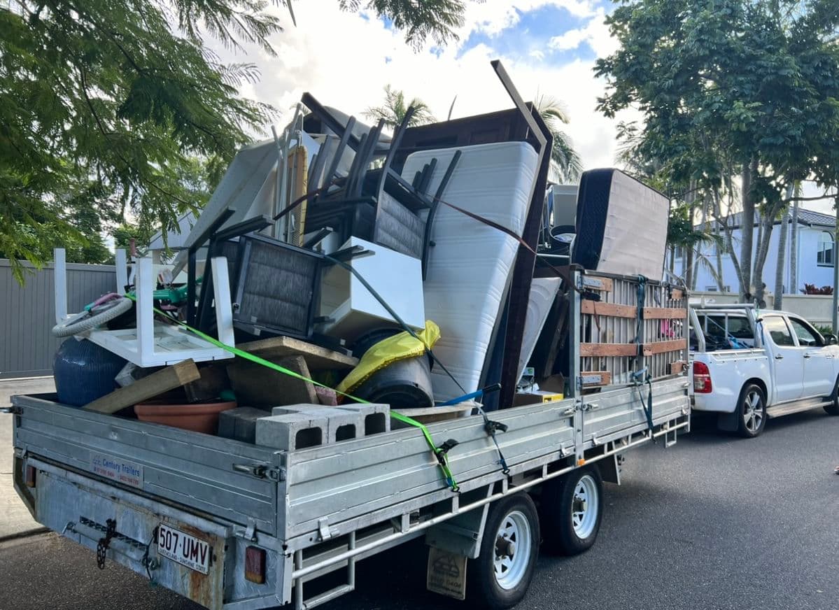 Workers loading renovation debris into a waste truck