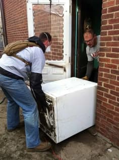 Moving an old refrigerator out of a kitchen for disposal