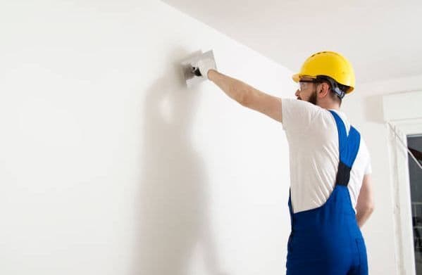 Plasterer applying a skim coat to a newly installed drywall